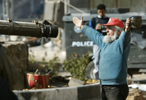 Christian Peacemaker Teammate Art Gish in Hebron in 2003 standing in front of an Israeli tank to try to stop it destroying a market in the Old City (AP Photo).